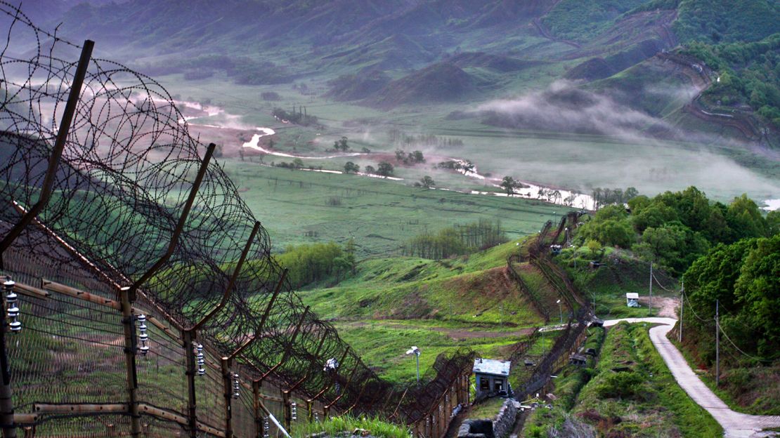 View of the DMZ with barbed wire fences and a distant guard post.